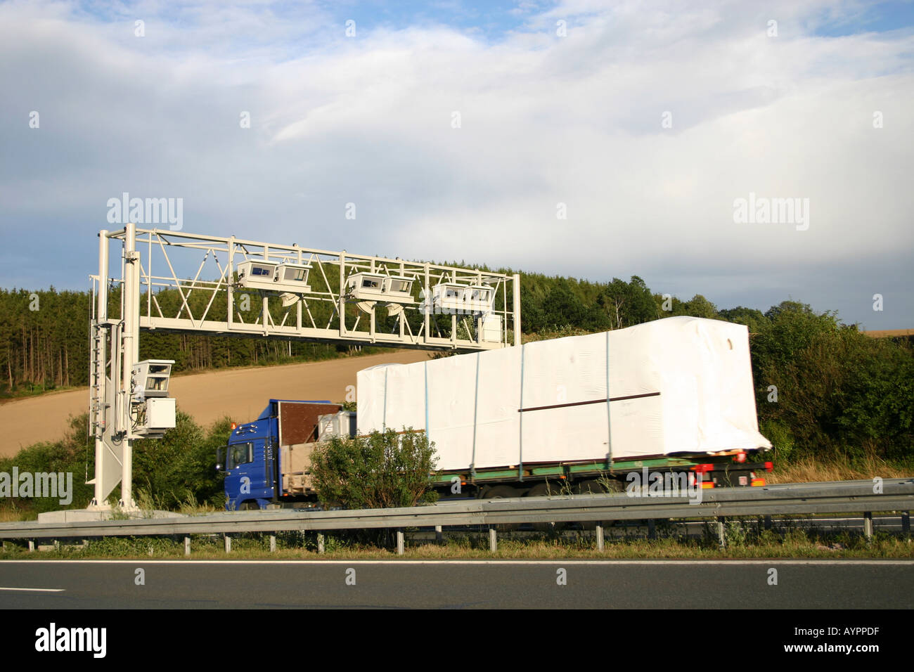 A truck seen near an overhead truss for registering the motorway toll Stock Photo