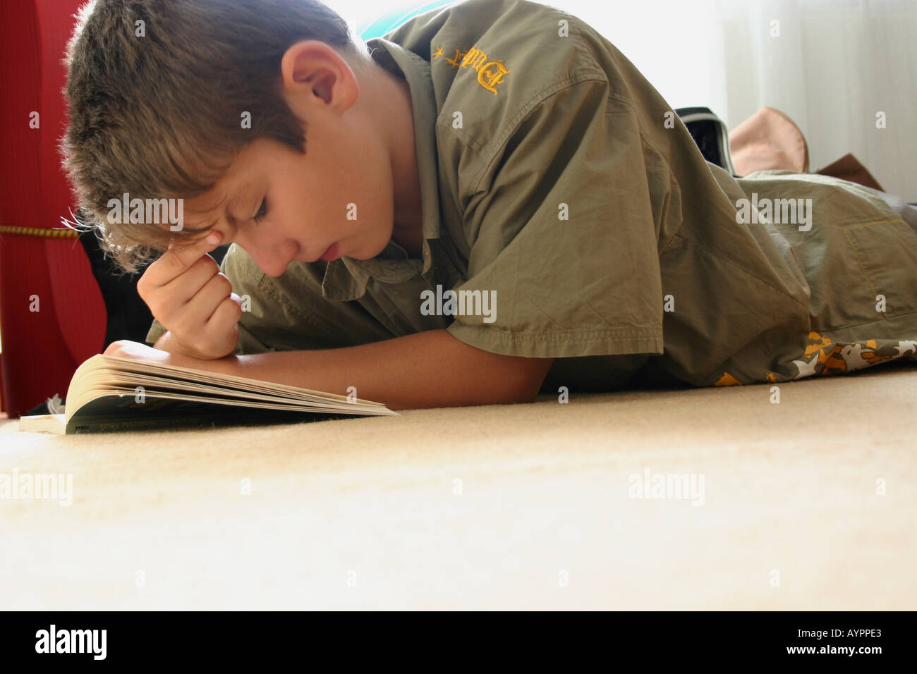 A young boy attentively reading his book Stock Photo