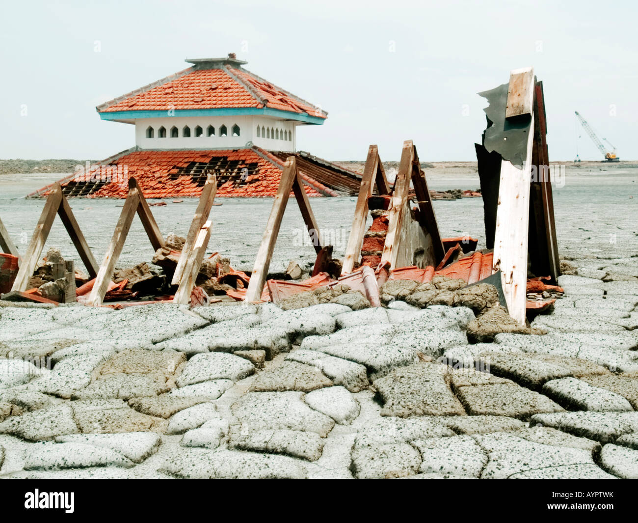 Broken rooftop of a house sticking out of the solidified mud,partly submerged mosque behind,Sidoarjo,East Java,Indonesia. Stock Photo
