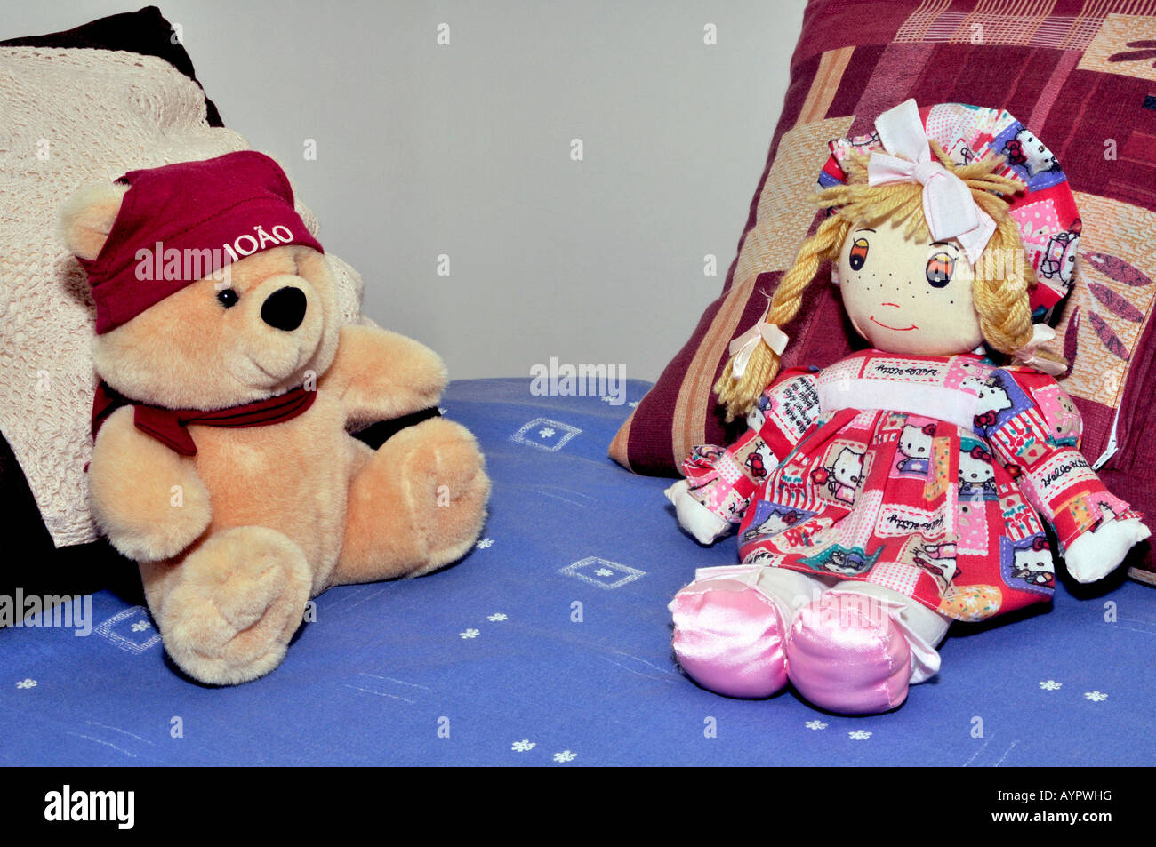 Dolls on a bed wth pillows behind Stock Photo Alamy