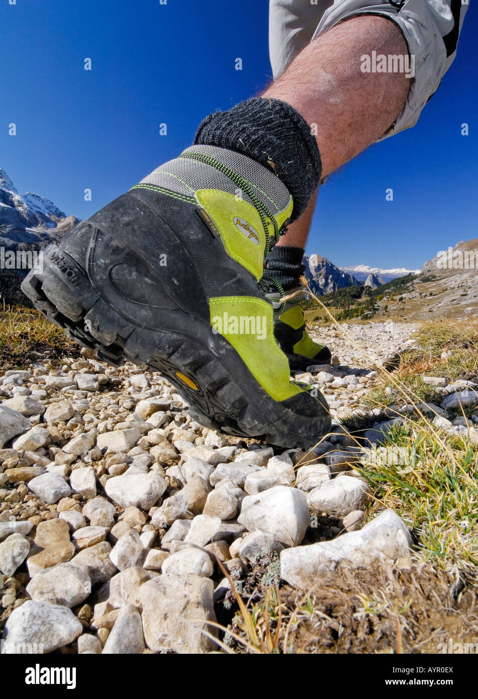 Yellow leather mountain climbing shoes, hiker on a trail wearing hiking boots, Bolzano-Bolzen, Italy Stock Photo