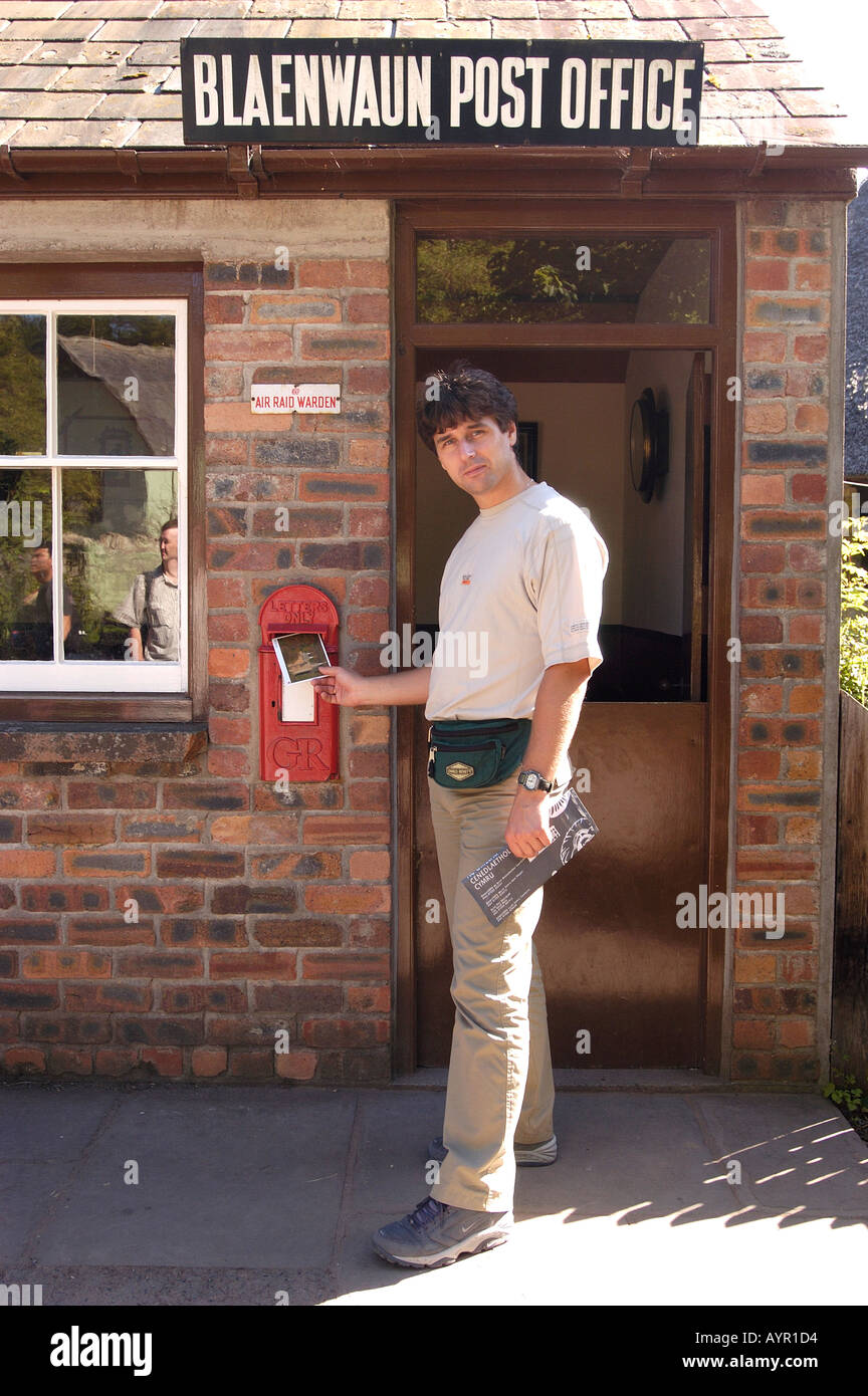 A man put postcard inside old post box outside of heritage Blaenwaun