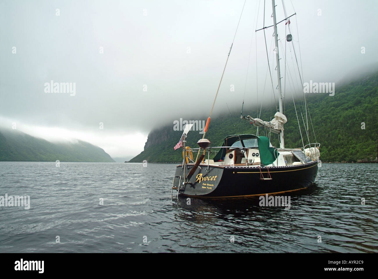 A cruising sailboat anchored in a fiord on the south Coast of Newfoundland Property release available Stock Photo