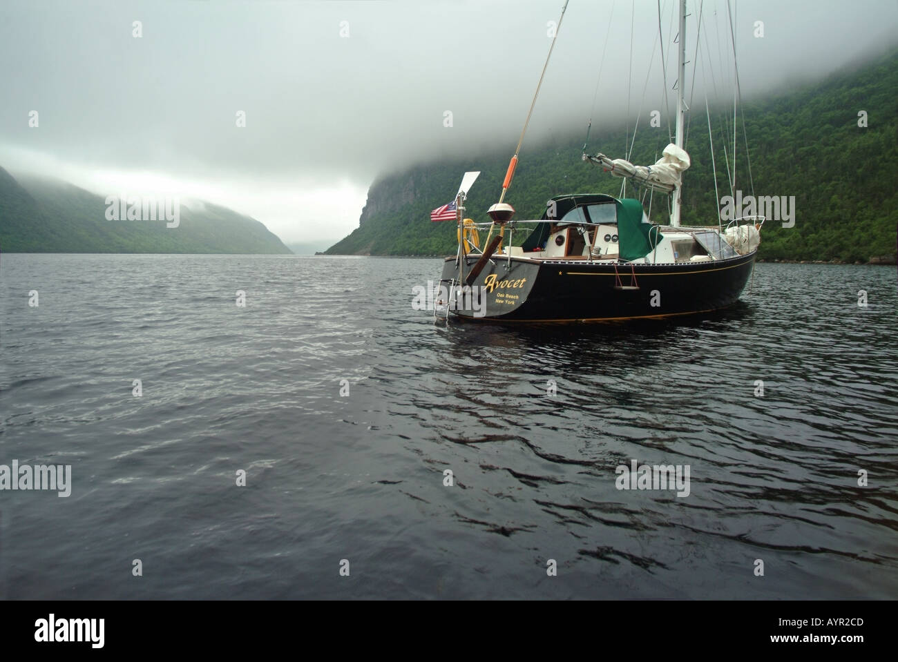 A cruising sailboat anchored in a fiord on the south Coast of Newfoundland Property release available Stock Photo