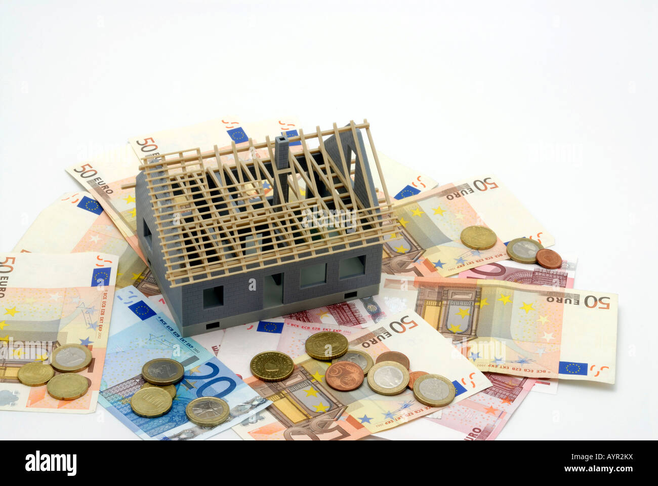 Building shell sitting on Euro cash and coins Stock Photo