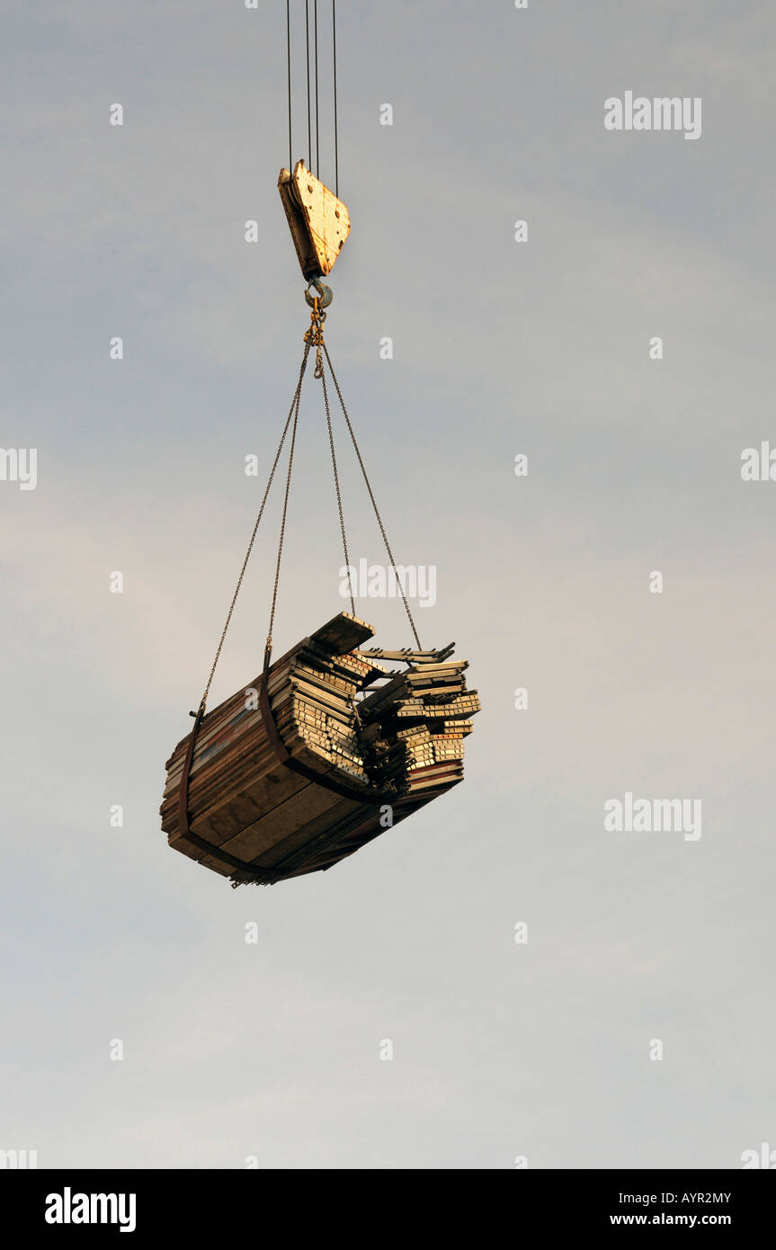 Scaffolding plank hanging from a building crane Stock Photo