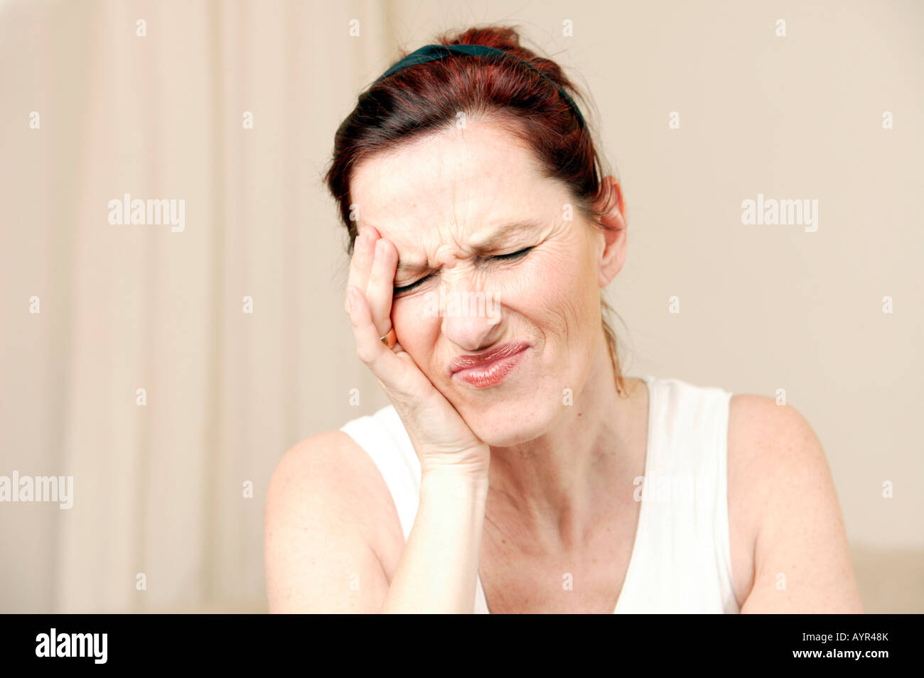 Middle-aged woman holding hand to her forehead Stock Photo