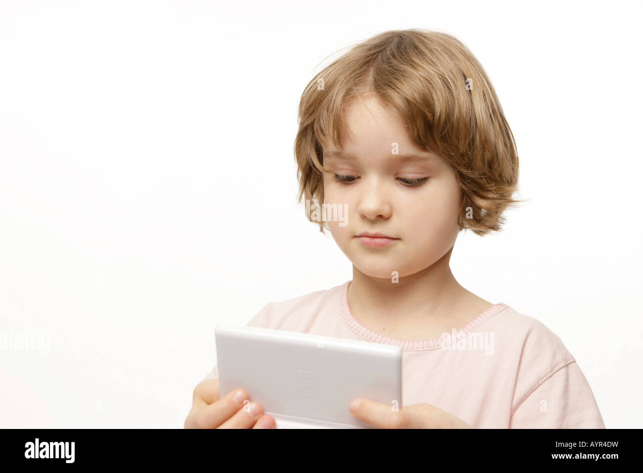 Eight-year-old girl playing with her pocket computer Stock Photo