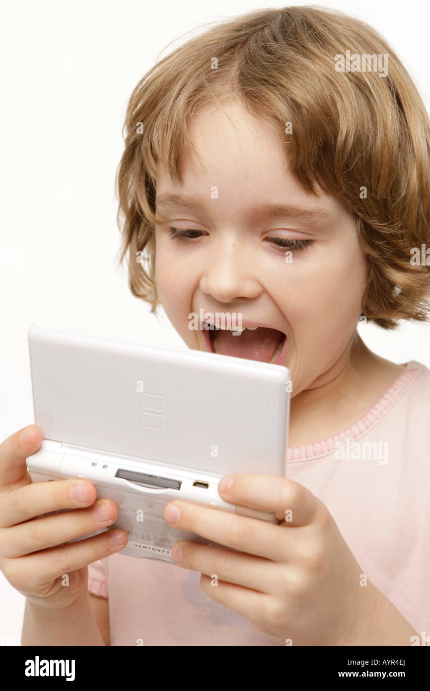 Eight-year-old girl playing with her pocket computer Stock Photo