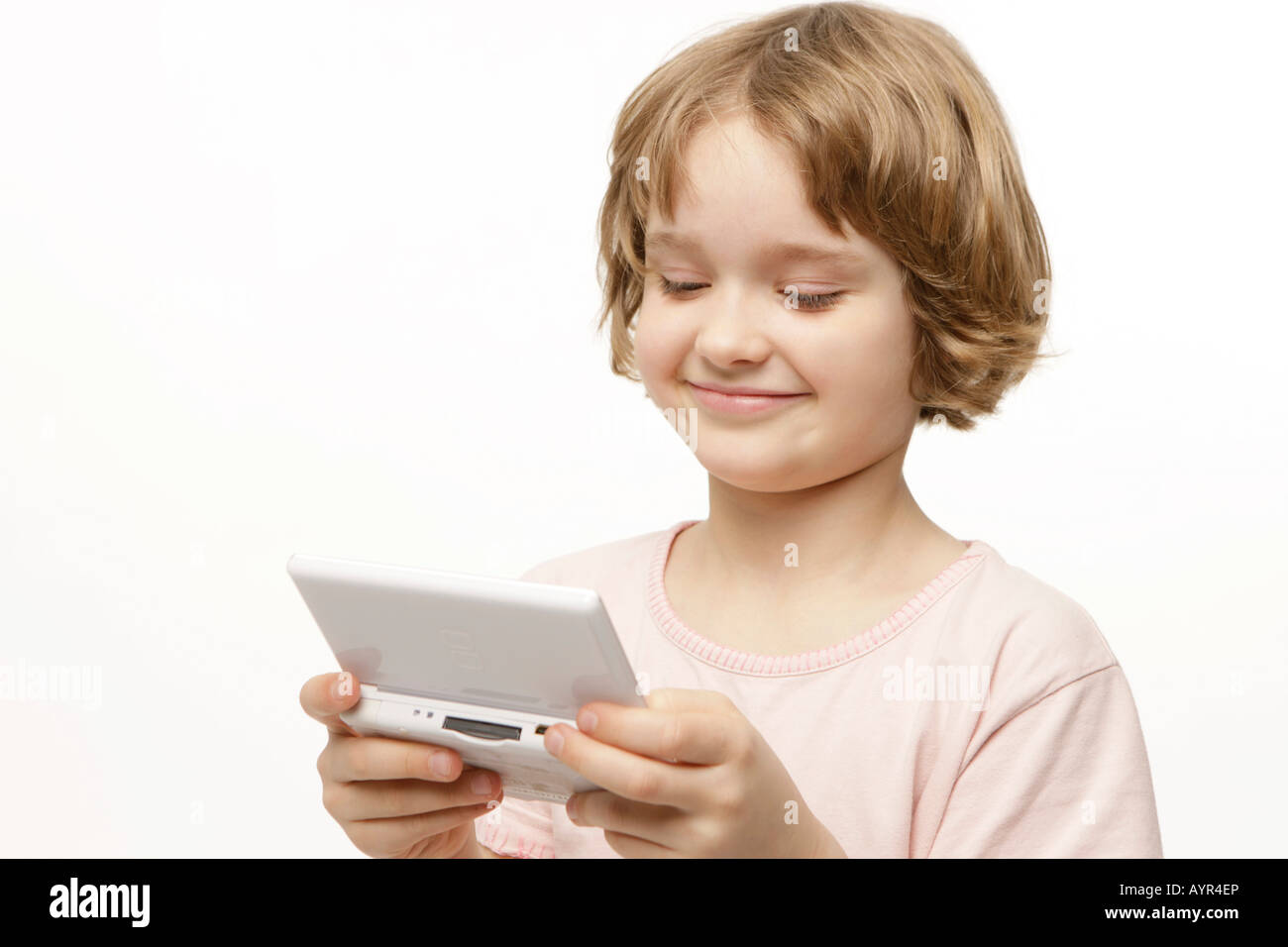 Eight-year-old girl playing with her pocket computer Stock Photo