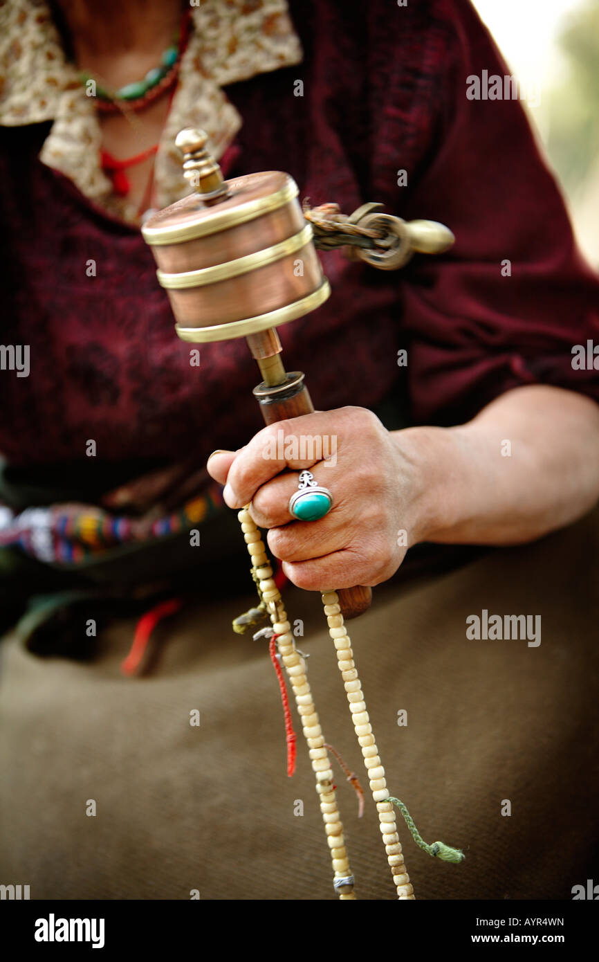 Close up detail of a spinning Tibetan prayer wheel and beads in hand Stock Photo