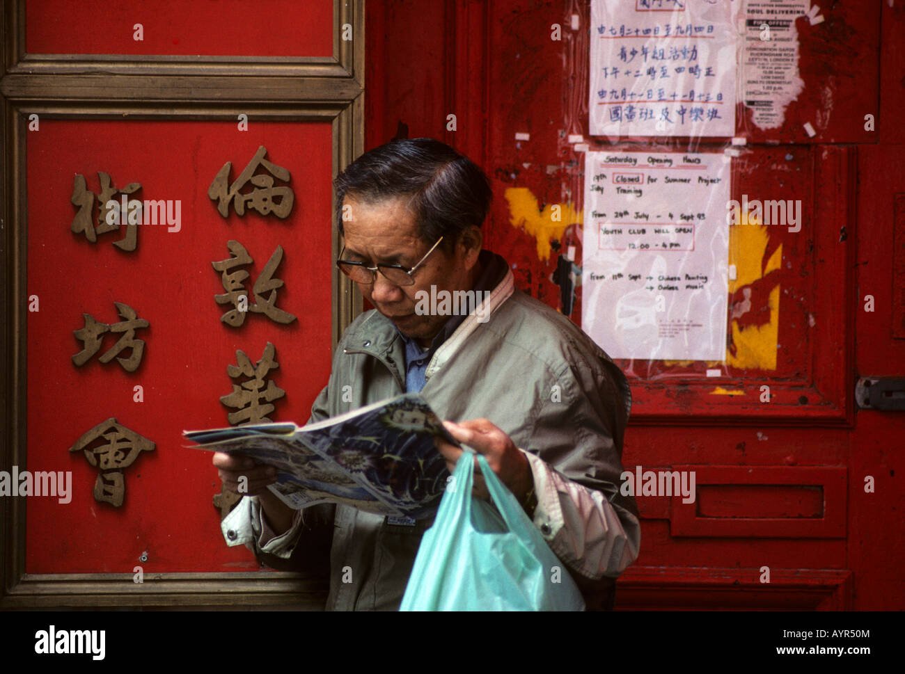 Chinese man reading a comic book in Chinatown, Soho, London, England, UK Stock Photo