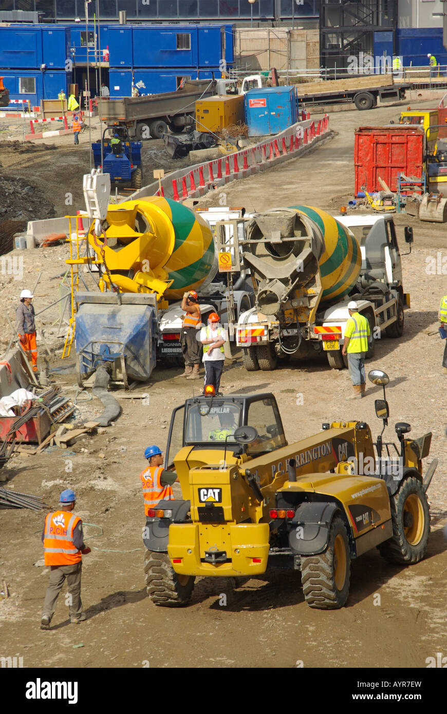 Development building site ready mix concrete delivery trucks and Cat