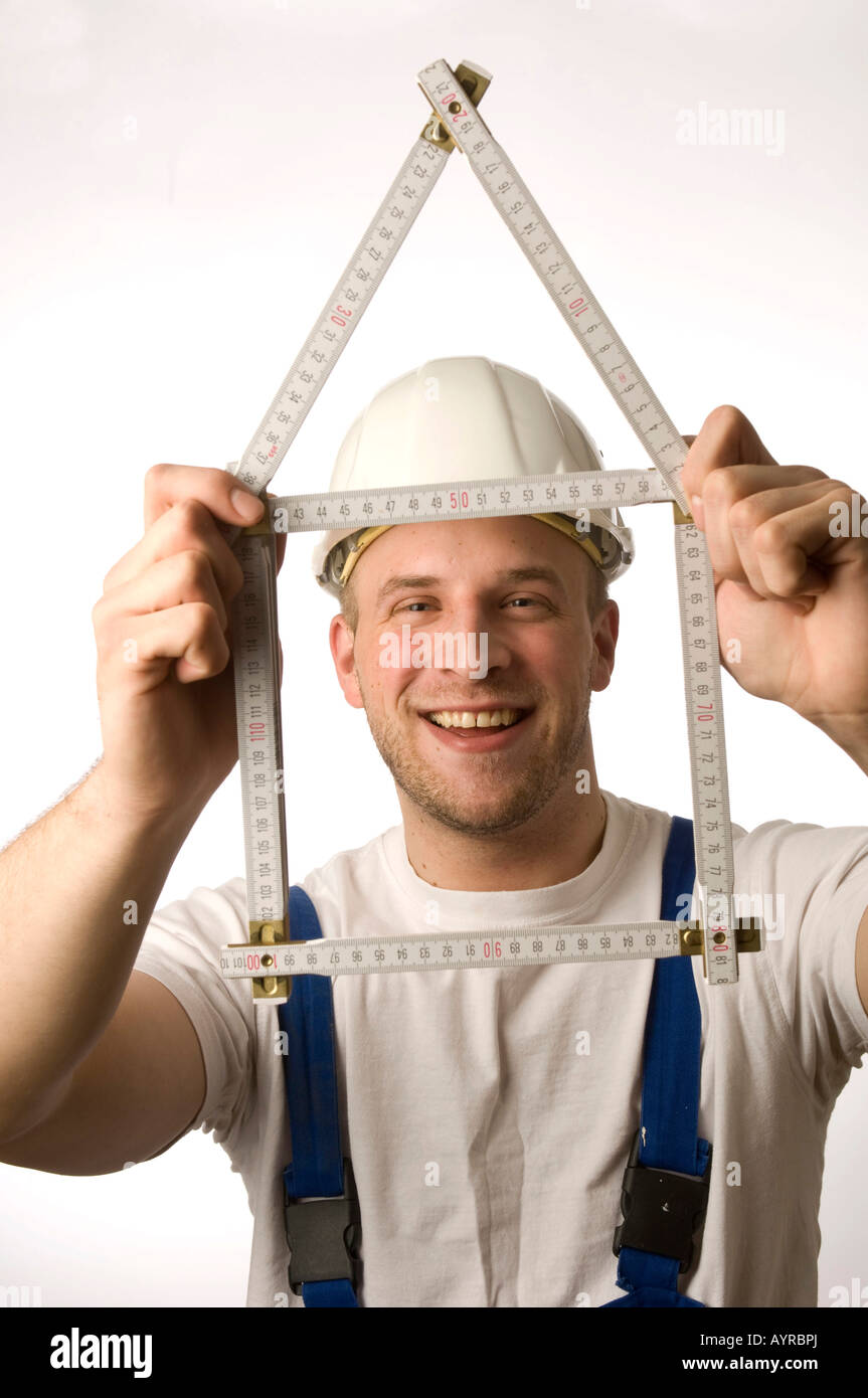 Construction worker holding folding rule (yardstick Stock Photo Alamy