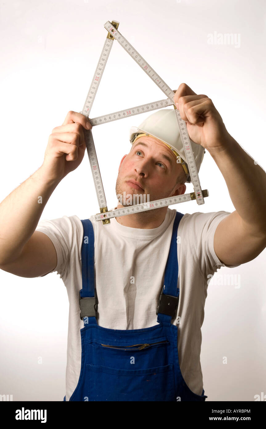 Construction worker holding folding rule (yardstick Stock Photo Alamy