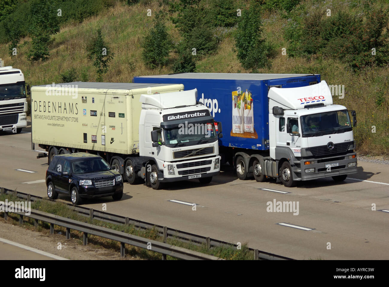 Debenhams and Tesco lorry with Range Rover car overtaking on M25 motorway Stock Photo