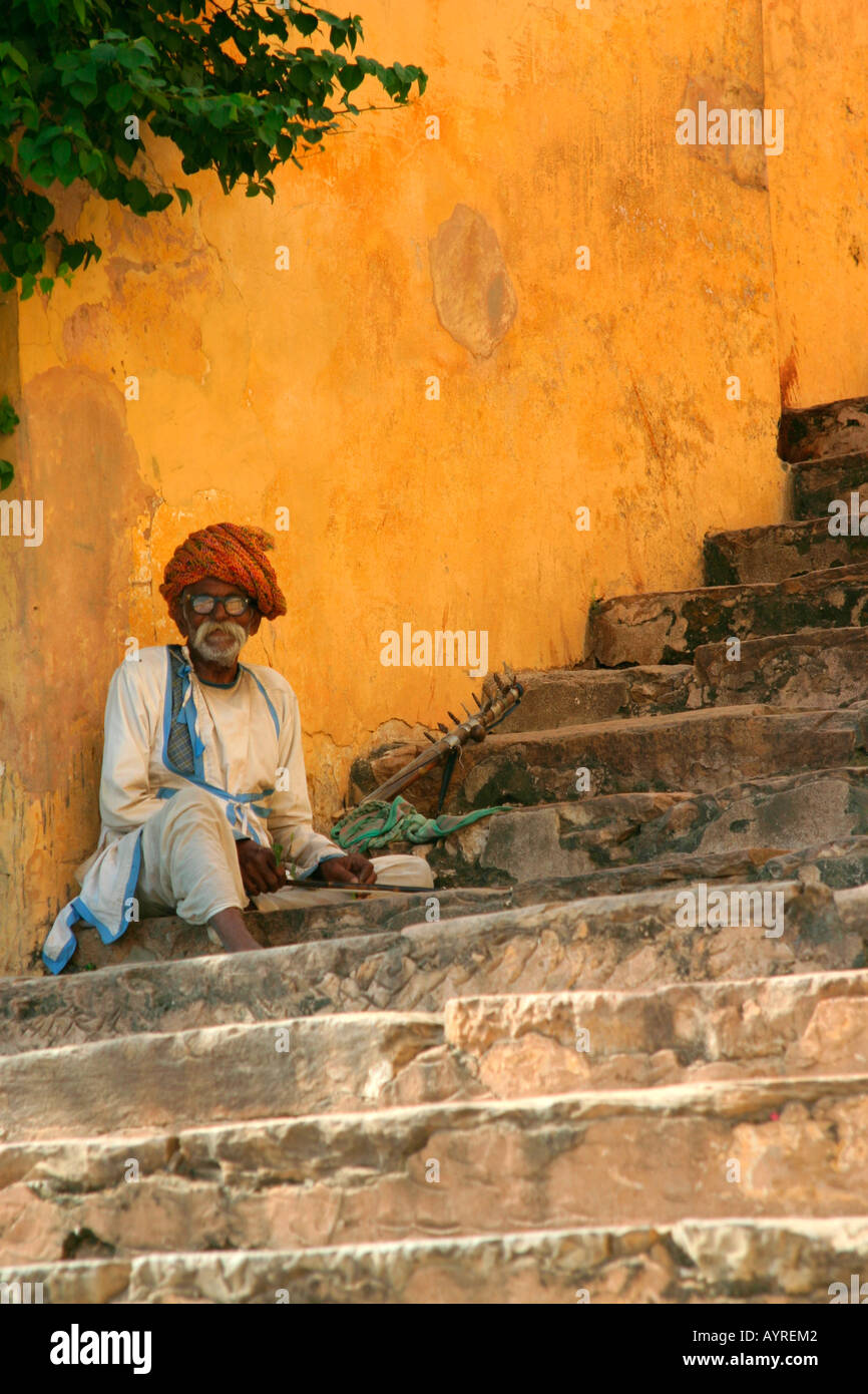Beggar sitting on stairs in traditional clothing, Jaipur, India Stock Photo
