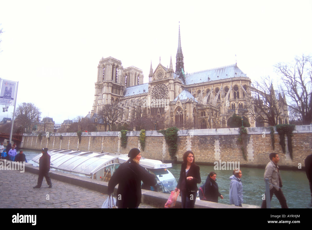Notre Dame in Paris France and a water taxi arriving along the Seine River. Stock Photo
