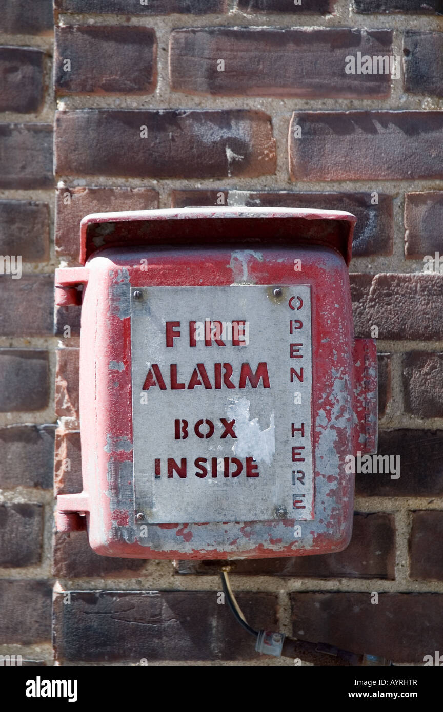 Fire alarm mounted on exterior brick wall Stock Photo