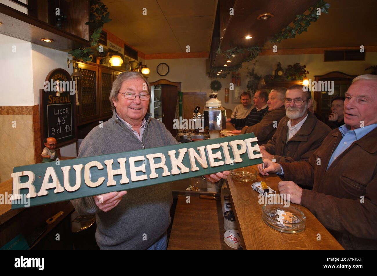 Host Winfried Krahwinkel (left, holding sign reading 'smoking bar') and his guests protesting the recently passed by-law prohib Stock Photo