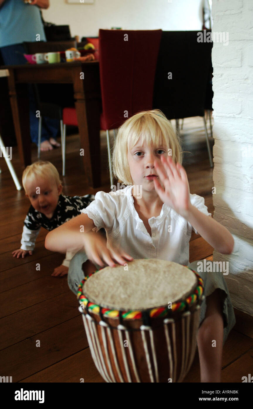 Five year old playing an African djembe drum Stock Photo