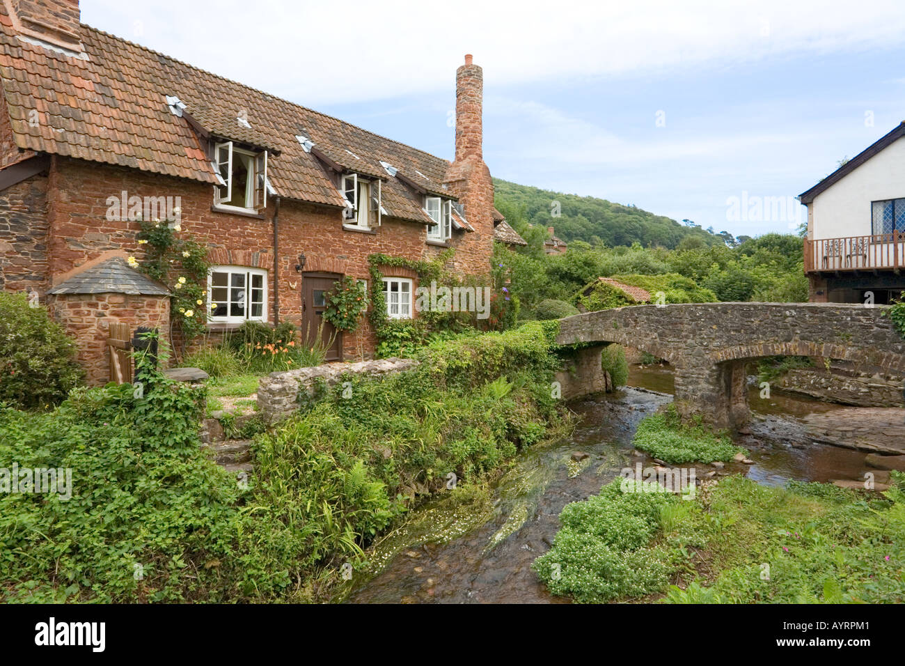 The shallow River Aller flowing under the ancient pack horse bridge at Allerford, Exmoor