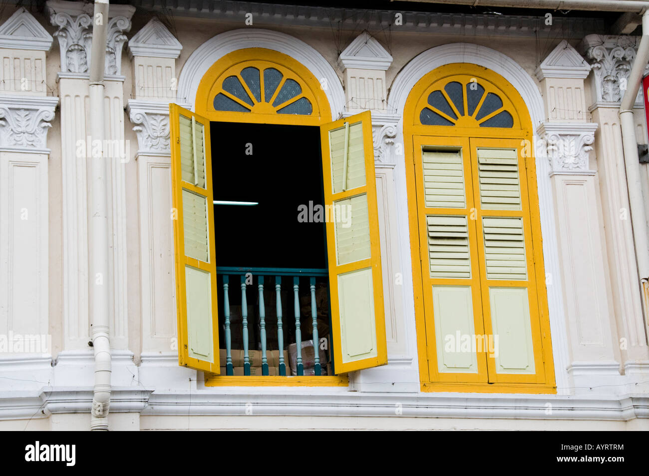 windows with shutters on second story apartment in Singapore Stock Photo