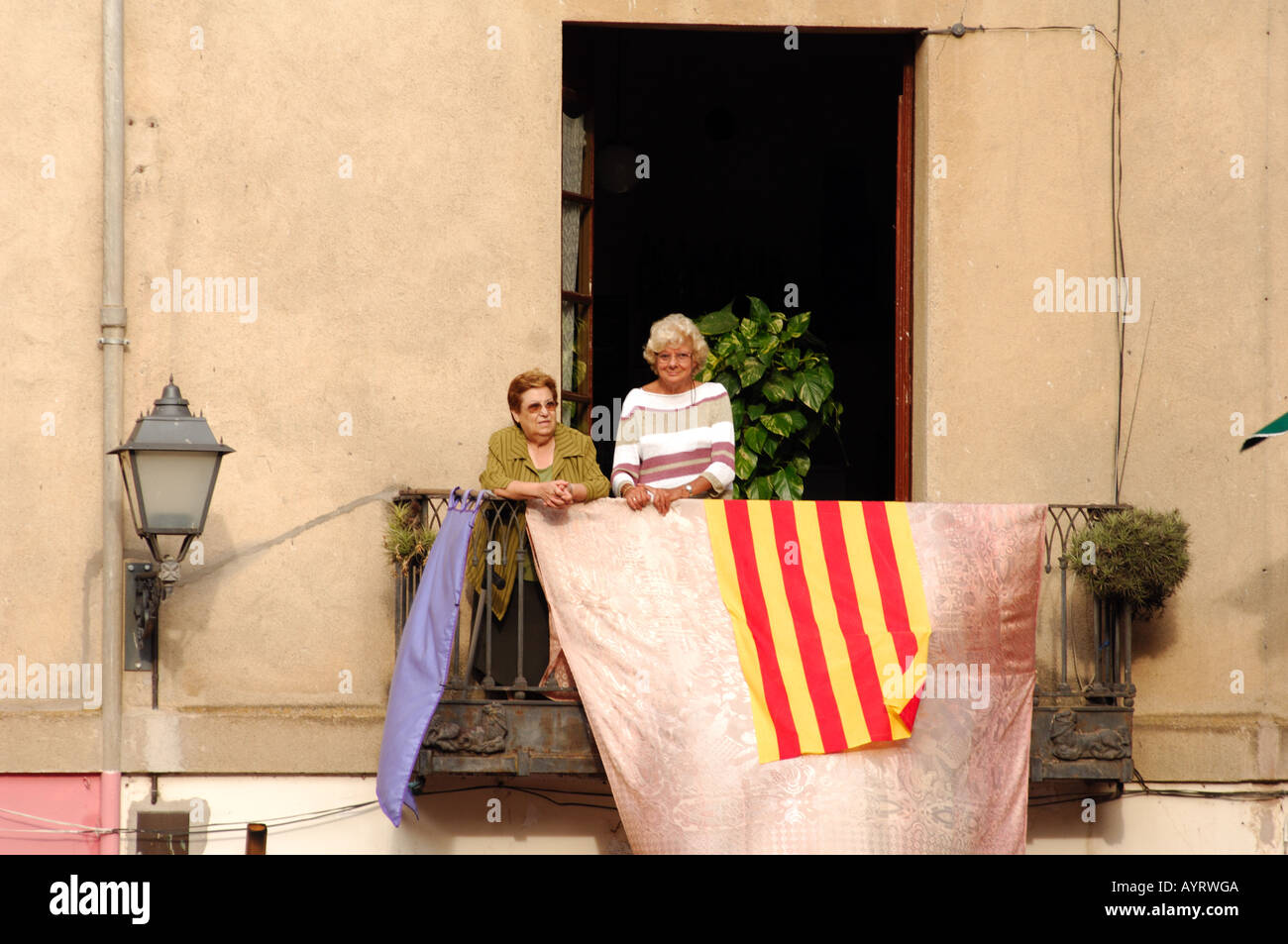 two elderly ladies on balcony watching the world go by during festival terra de trobadors castello d'empuries catalonia spain Stock Photo