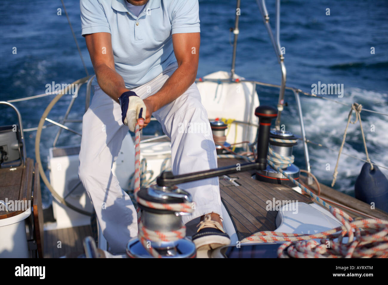 Man on a sailboat pulling a rope Stock Photo Alamy