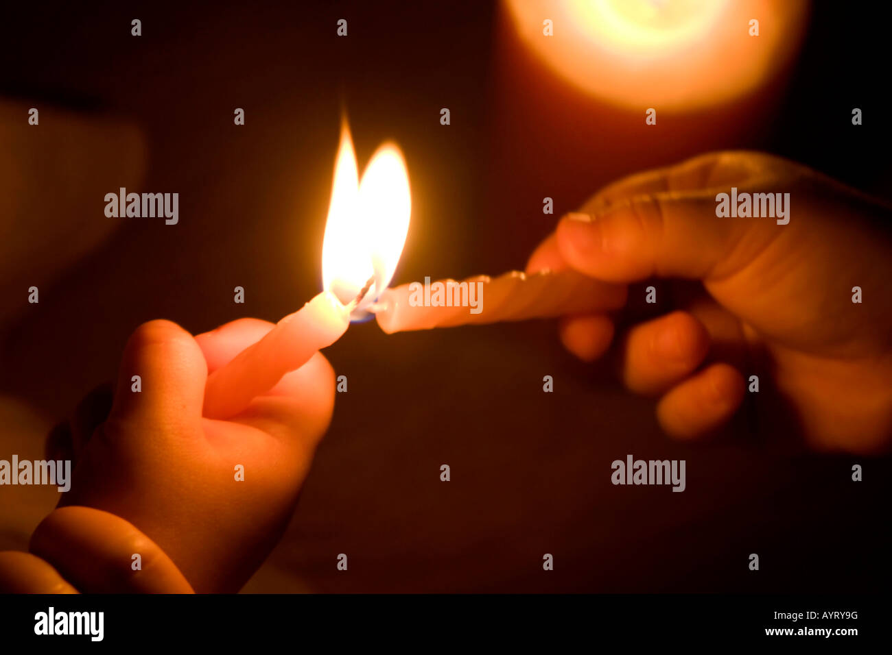 Child's hands lighting a candle Stock Photo