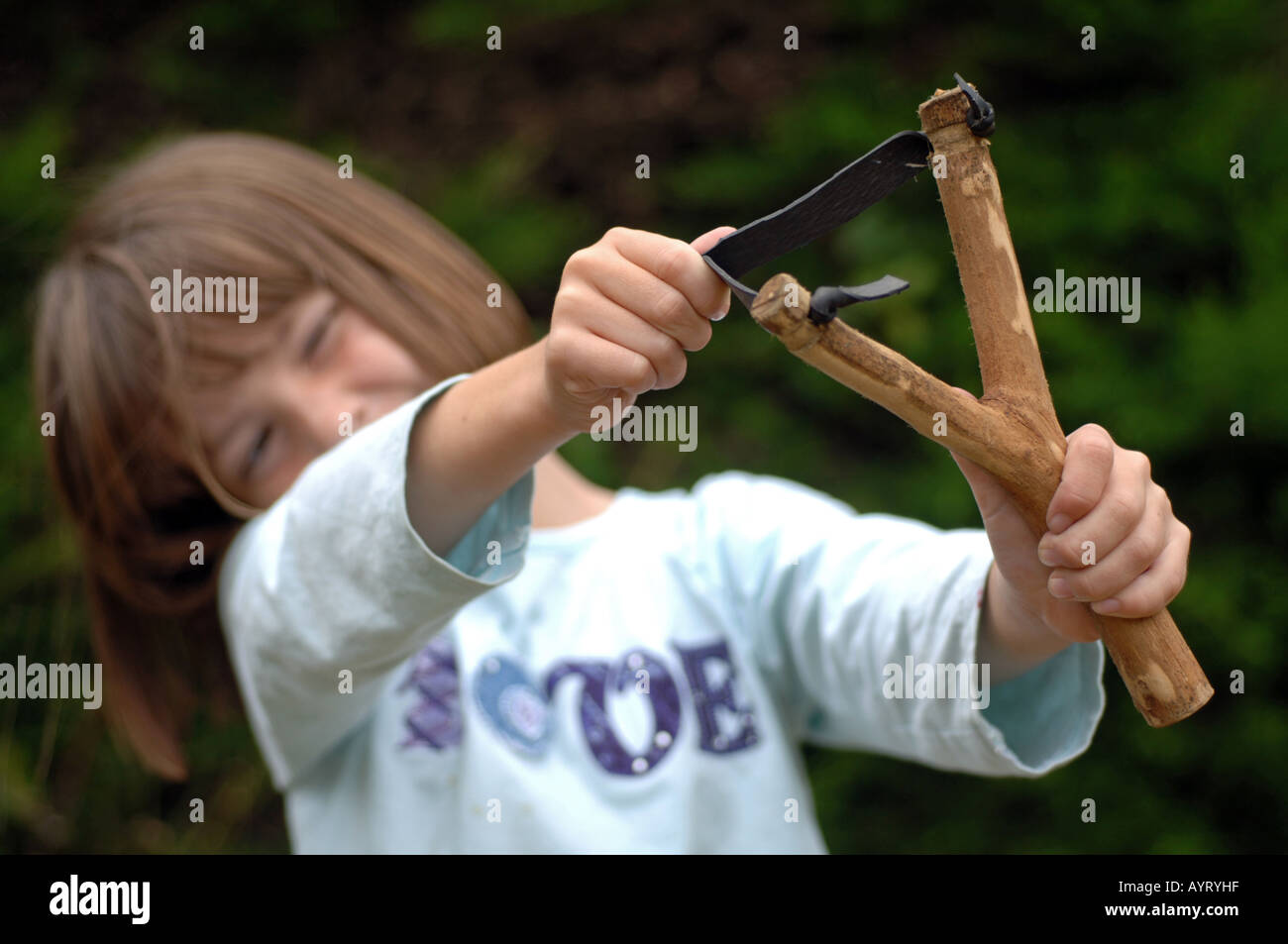 Girl using a catapult or slingshot Stock Photo