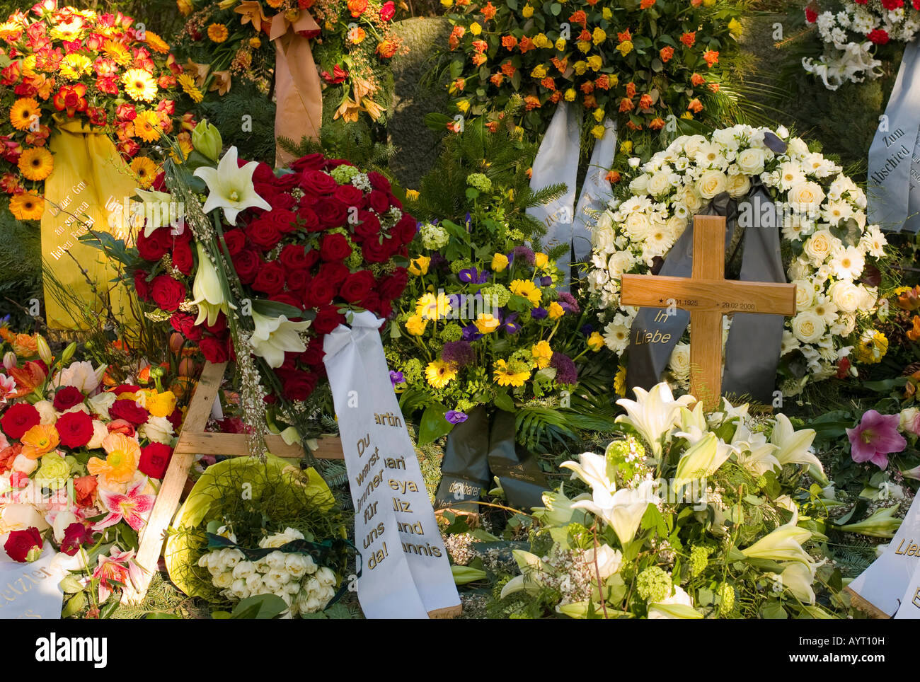Fresh grave decorated with countless flowers at a cemetery in Germany Stock Photo