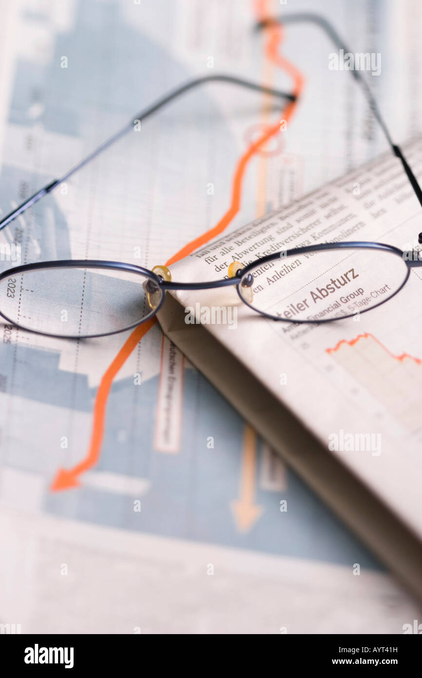 Glasses on on newspaper showing falling stock prices Stock Photo