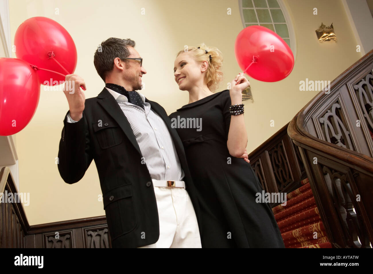 Couple with balloons on a staircase Stock Photo - Alamy