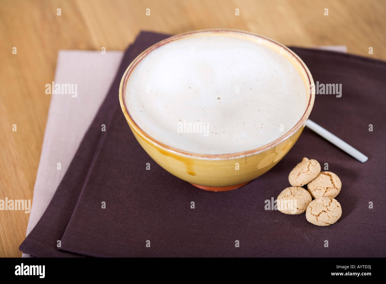 Bowl with white coffee lying on a table napkin Stock Photo