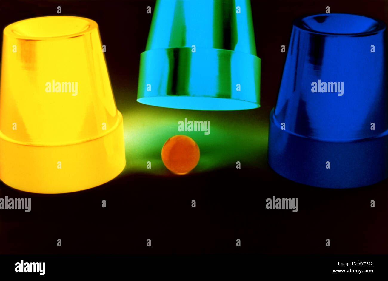 Shell game with three plastic cups and marble Stock Photo Alamy