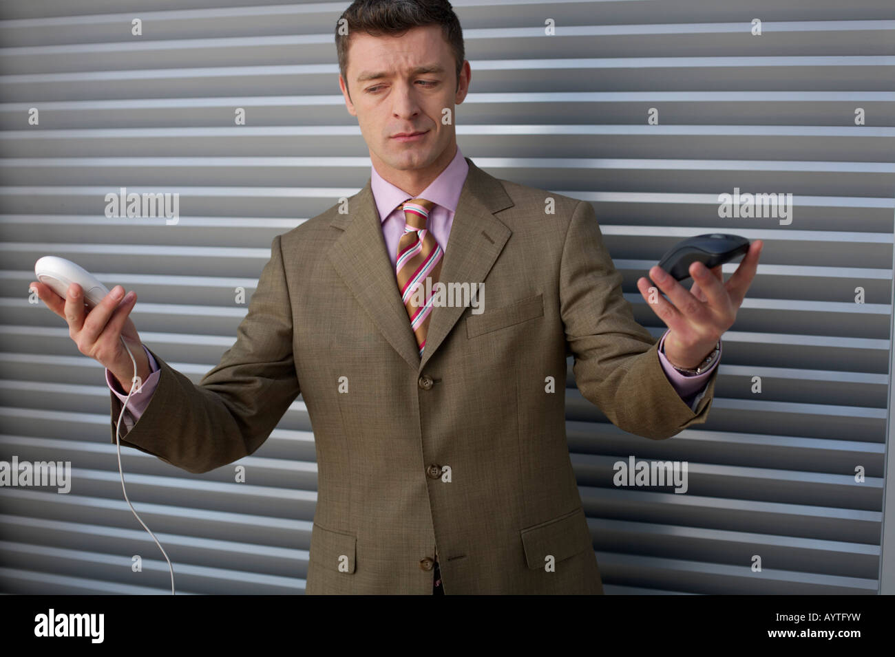 Businessman holding two computer mouses on hands Stock Photo - Alamy