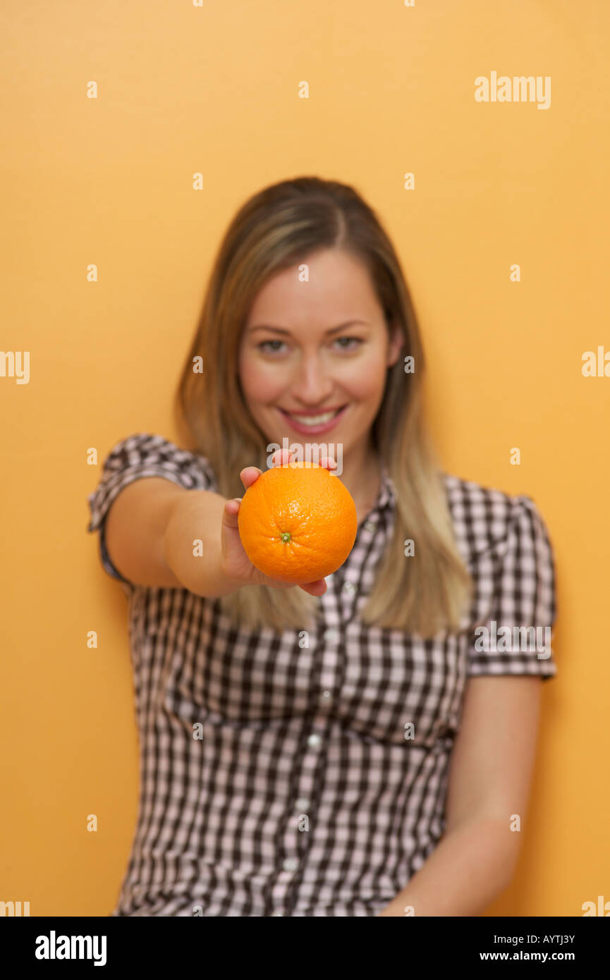 A woman is holding an orange in her hand Stock Photo - Alamy