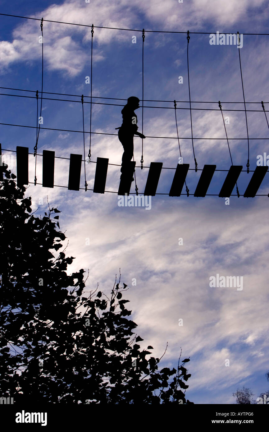 Silhouette of girl high up walking across bridge Stock Photo - Alamy