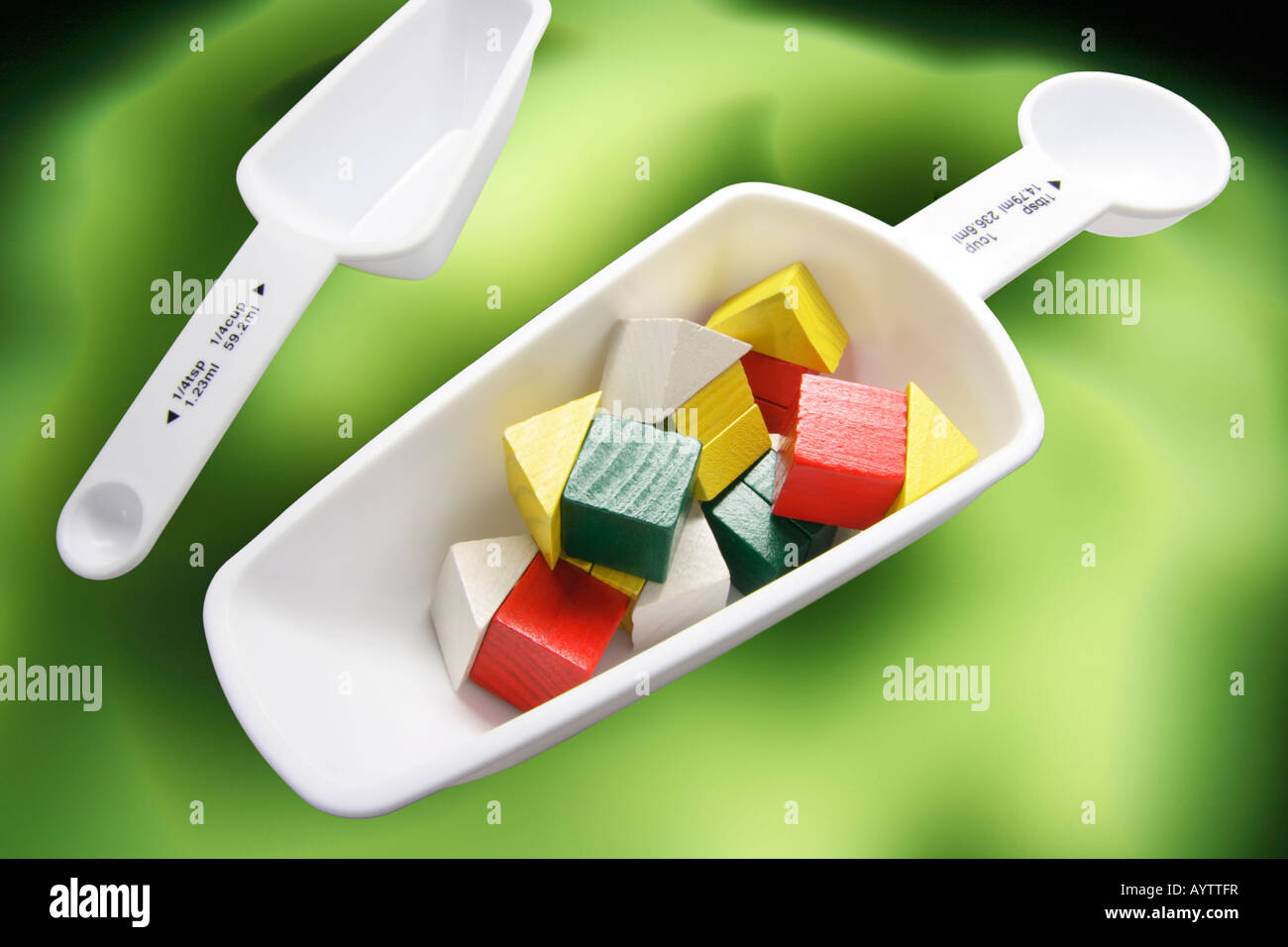 Measuring Spoons with Wooden Toy Houses Stock Photo