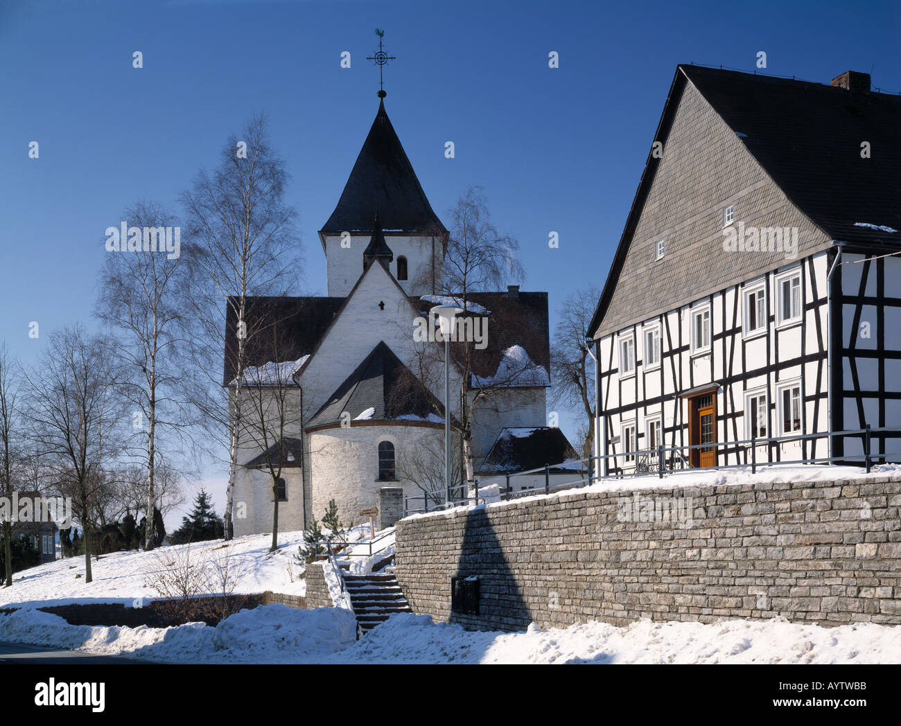 Kirche von Berghausen und Fachwerkhaus im Schnee, Schmallenberg-Berghausen, Naturpark Rothaargebirge, Sauerland, Nordrhein-Westfalen Stock Photo