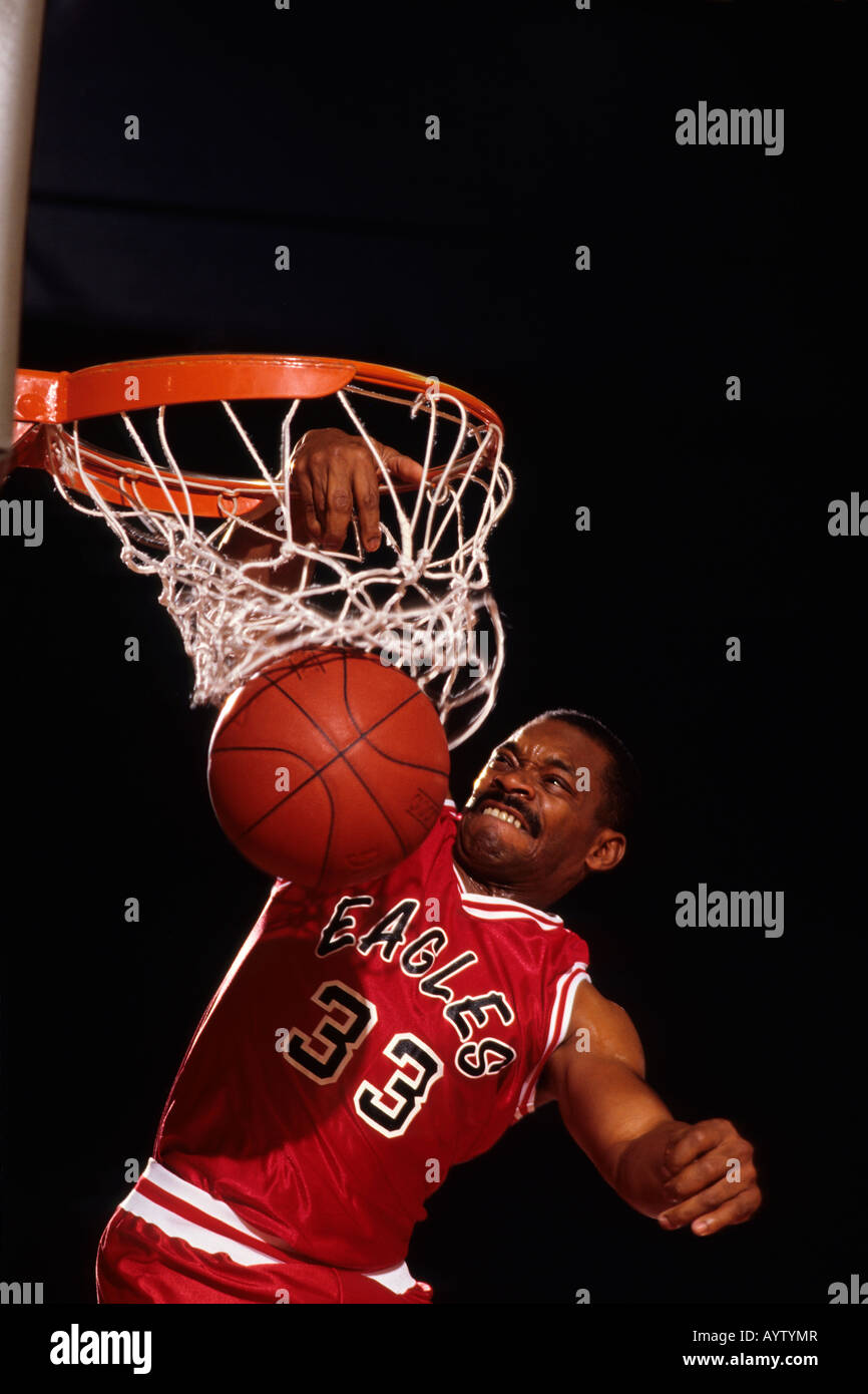 Male basketball player slam dunking a basket Stock Photo