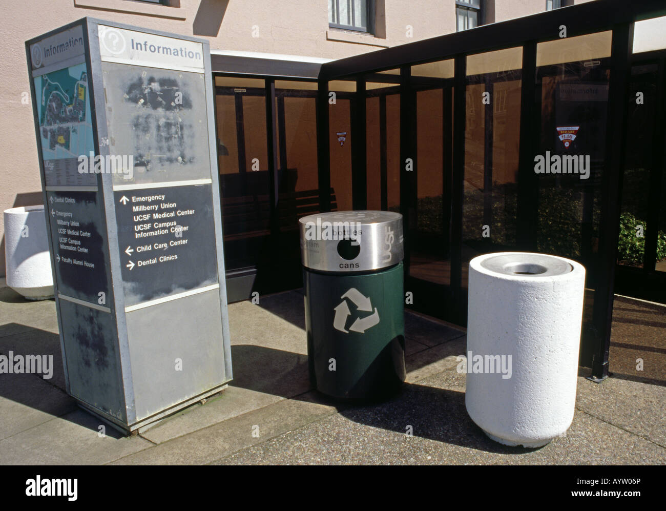 trash and recycling receptacles and information and map sign at a bus ...
