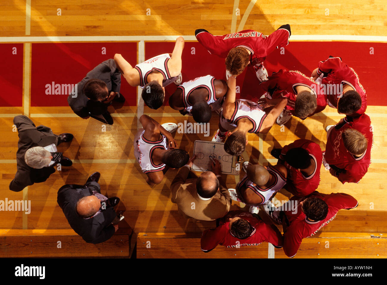 Overhead view of coach instructing High School basketball team Stock Photo