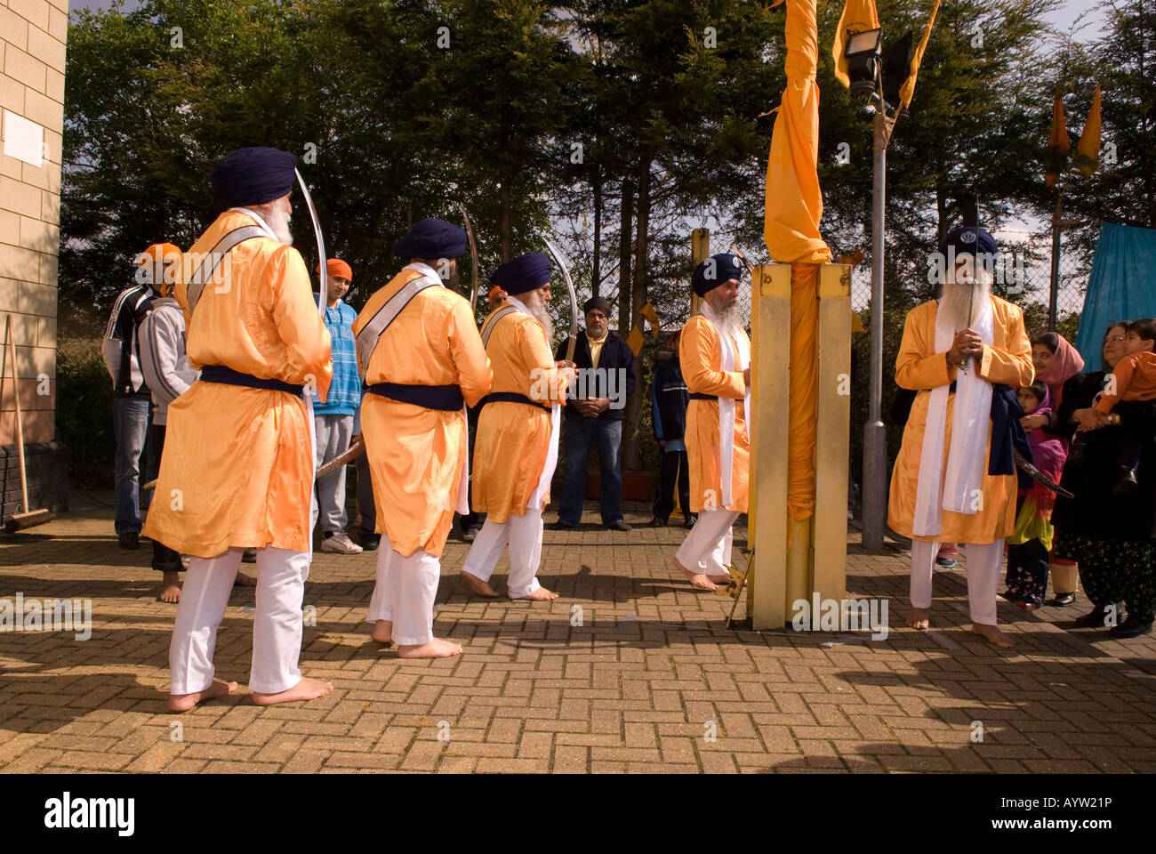 The five pure ones [Khalsa] walking around the newly hoisted Nishan Sahib flag during Vaisakhi festival Stock Photo
