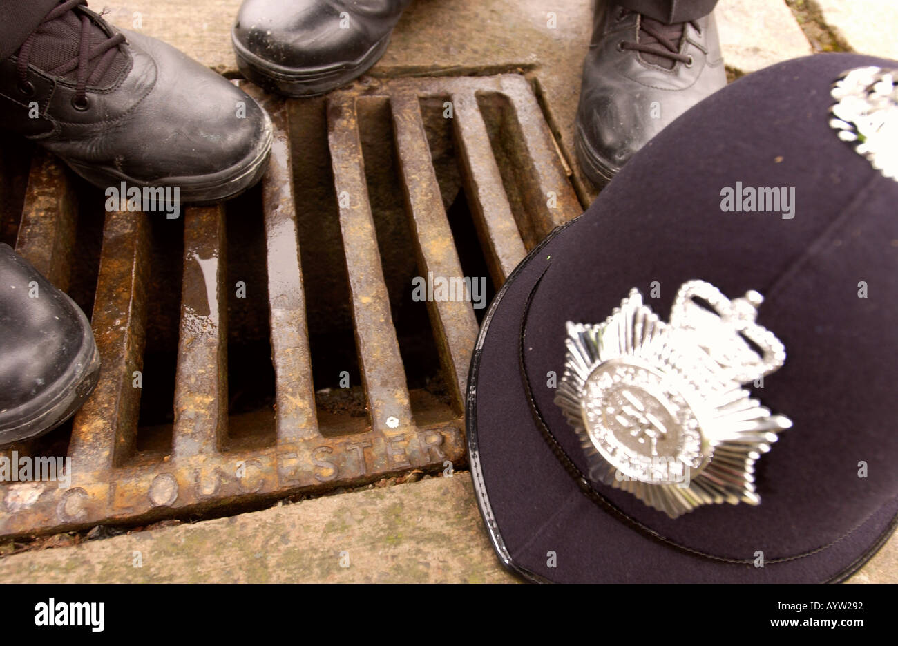 POLICE GUARD A DRAIN COVER IN GLOUCESTER CITY CENTRE SFTER THEFTS DUE TO THE HIGH PRICE IRONWORK FOR SCRAP MARCH 2004 Stock Photo