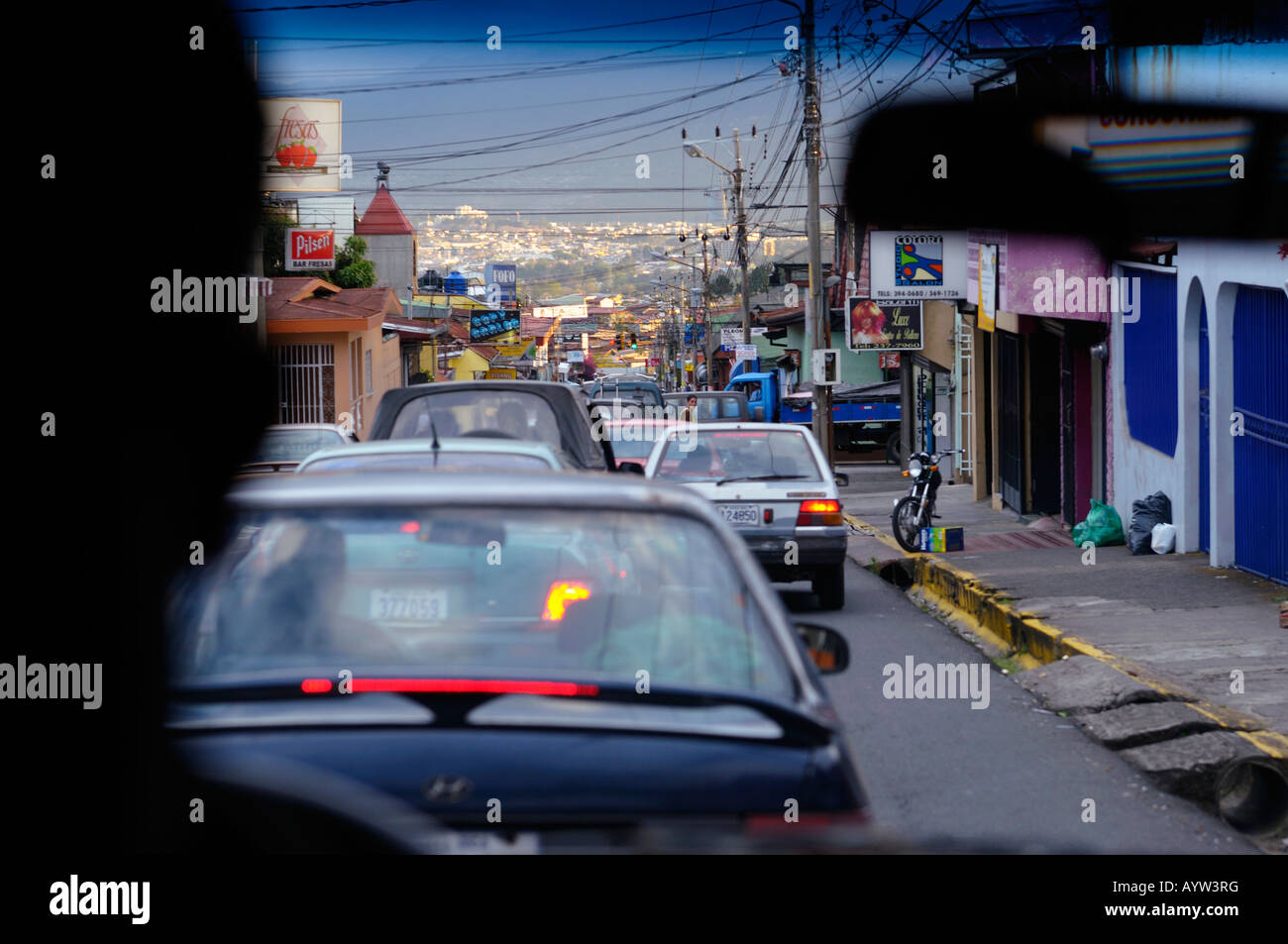 Traffic jam in Heredia looking toward golden San Jose in the distance from inside a taxi Stock Photo