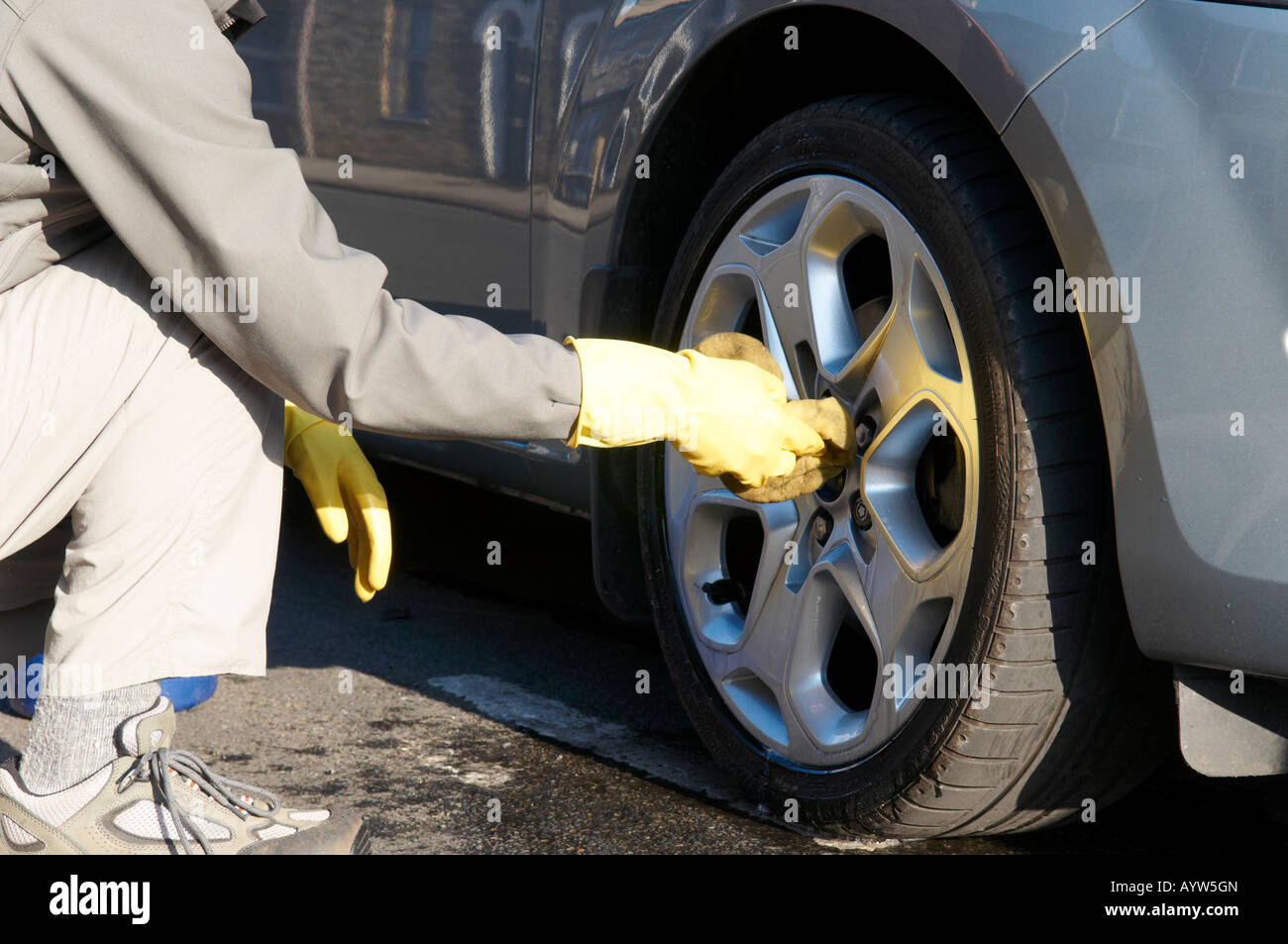 Man cleaning his alloy wheels on Ford Mondeo 2007 New Stock Photo - Alamy
