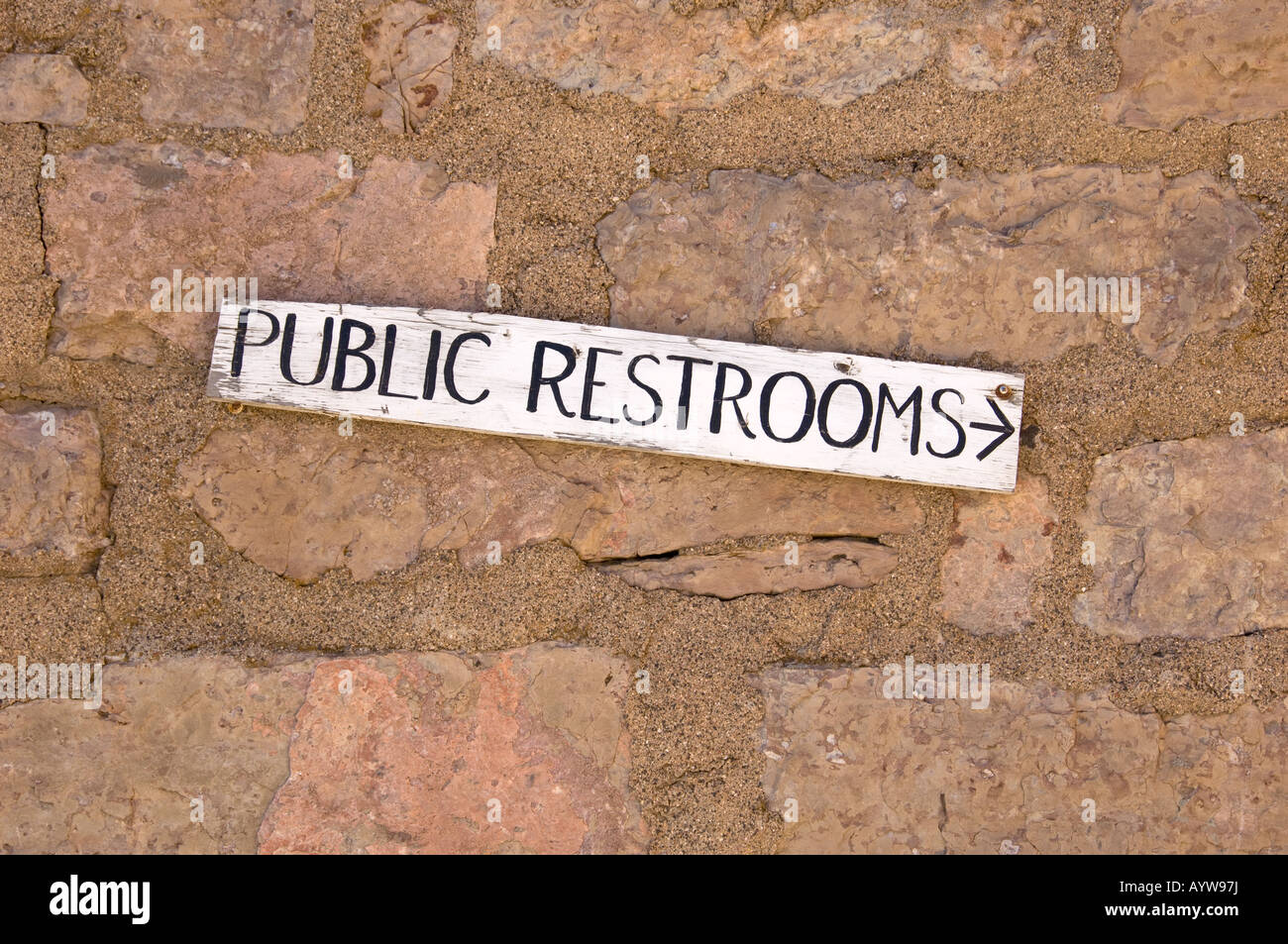 Public Restroom sign a brick wall Stock Photo