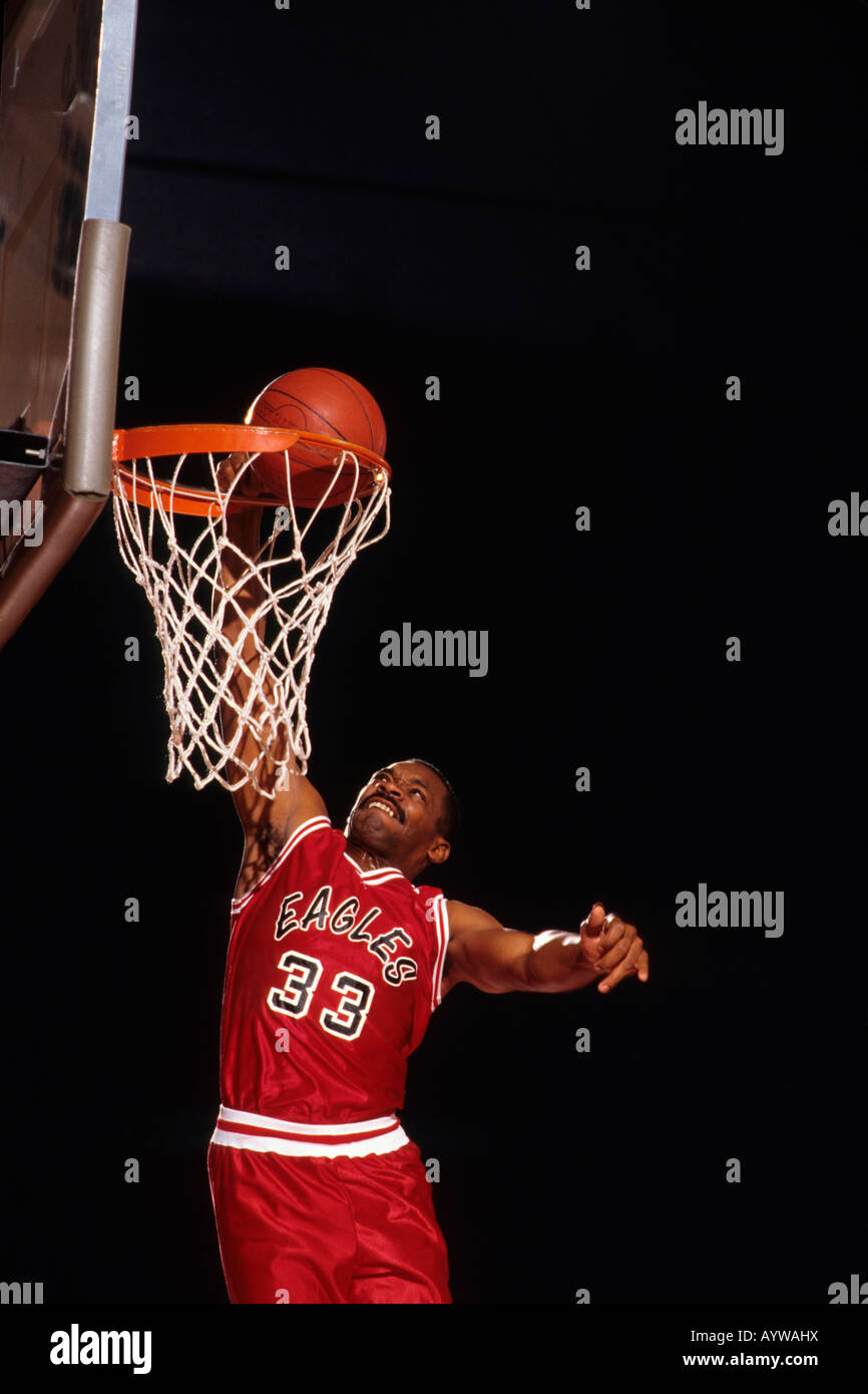 Male basketball player slam dunking a basket Stock Photo